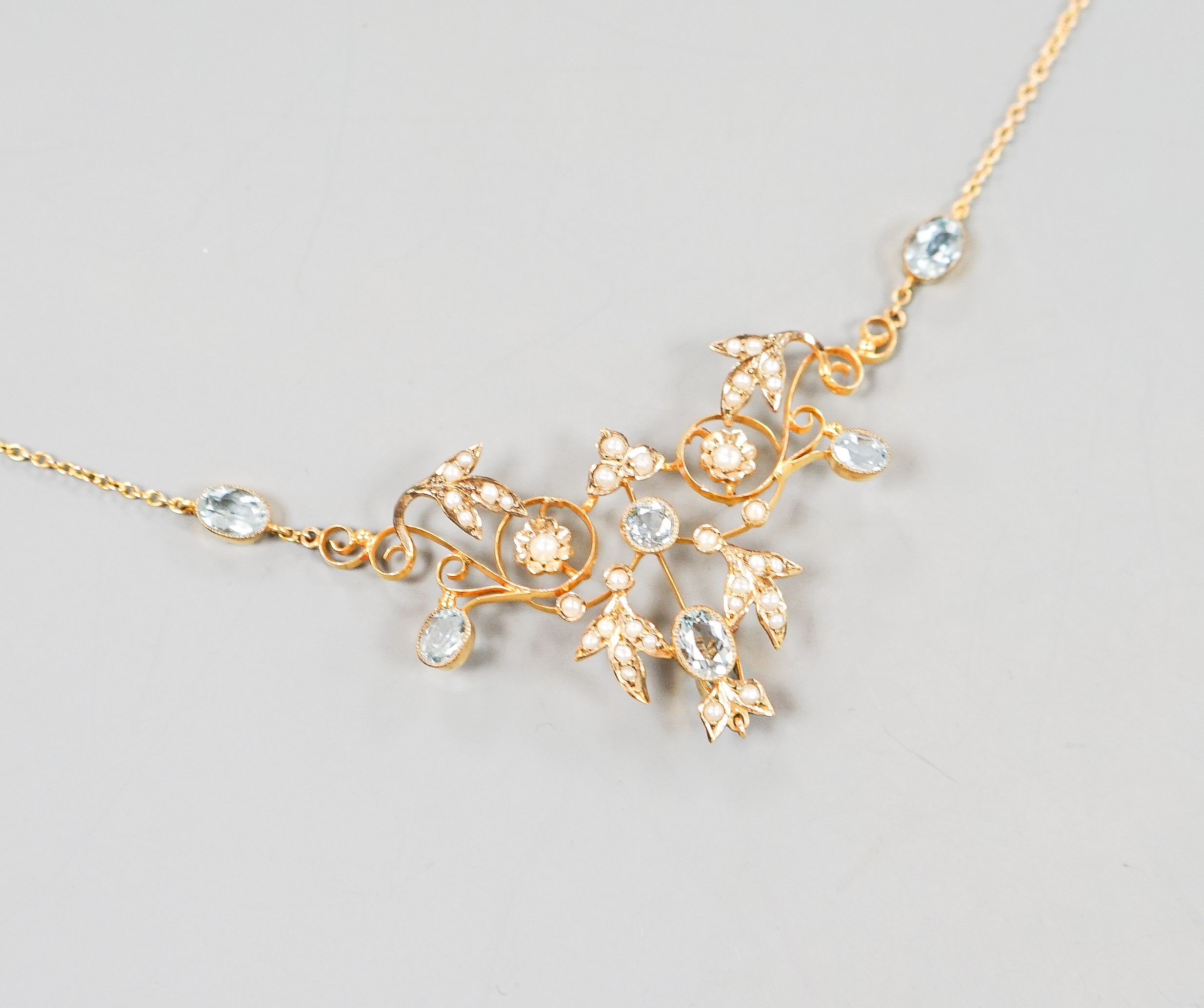 An Edwardian 9ct, aquamarine and seed pearl set drop pendant necklace, 40cm, gross weight 7.2 grams.